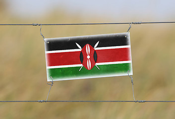 Image showing Border fence - Old plastic sign with a flag