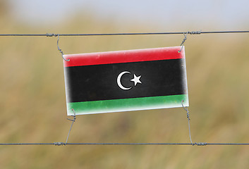 Image showing Border fence - Old plastic sign with a flag