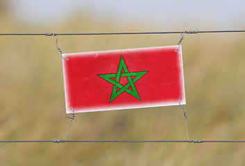 Image showing Border fence - Old plastic sign with a flag