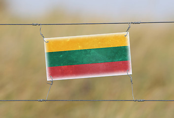 Image showing Border fence - Old plastic sign with a flag