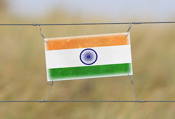 Image showing Border fence - Old plastic sign with a flag