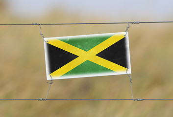 Image showing Border fence - Old plastic sign with a flag