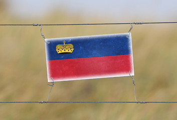 Image showing Border fence - Old plastic sign with a flag