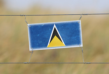 Image showing Border fence - Old plastic sign with a flag