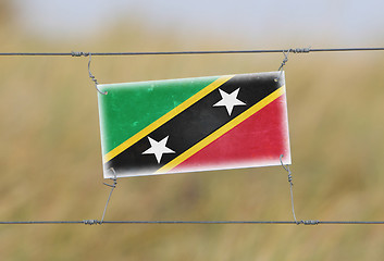 Image showing Border fence - Old plastic sign with a flag