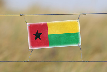 Image showing Border fence - Old plastic sign with a flag