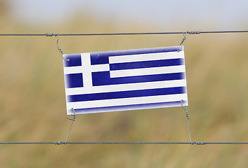 Image showing Border fence - Old plastic sign with a flag