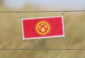 Image showing Border fence - Old plastic sign with a flag