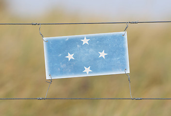 Image showing Border fence - Old plastic sign with a flag