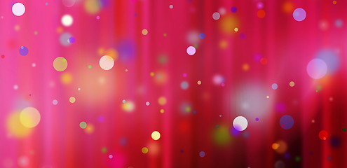 Image showing confetti against a red blurred curtain background