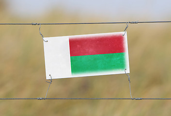 Image showing Border fence - Old plastic sign with a flag