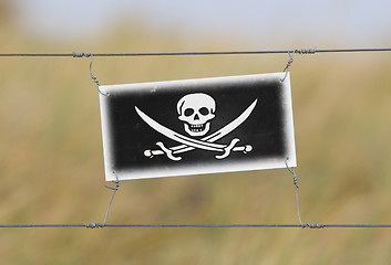 Image showing Border fence - Old plastic sign with a flag