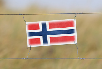 Image showing Border fence - Old plastic sign with a flag