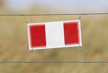 Image showing Border fence - Old plastic sign with a flag