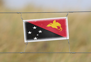 Image showing Border fence - Old plastic sign with a flag