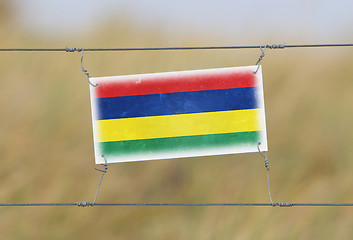 Image showing Border fence - Old plastic sign with a flag