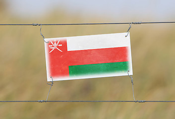 Image showing Border fence - Old plastic sign with a flag