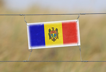 Image showing Border fence - Old plastic sign with a flag