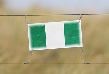 Image showing Border fence - Old plastic sign with a flag