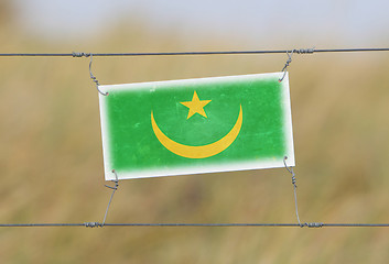 Image showing Border fence - Old plastic sign with a flag