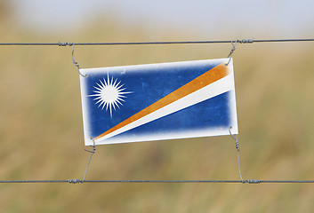 Image showing Border fence - Old plastic sign with a flag