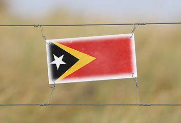 Image showing Border fence - Old plastic sign with a flag