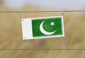 Image showing Border fence - Old plastic sign with a flag