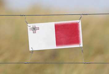 Image showing Border fence - Old plastic sign with a flag