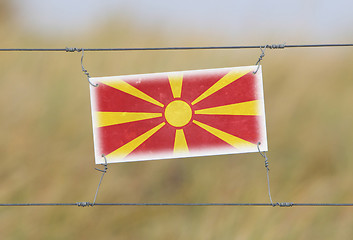 Image showing Border fence - Old plastic sign with a flag