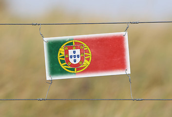 Image showing Border fence - Old plastic sign with a flag