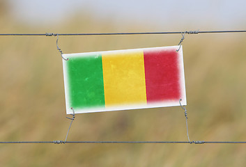 Image showing Border fence - Old plastic sign with a flag