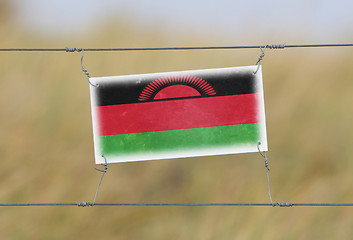 Image showing Border fence - Old plastic sign with a flag