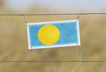 Image showing Border fence - Old plastic sign with a flag