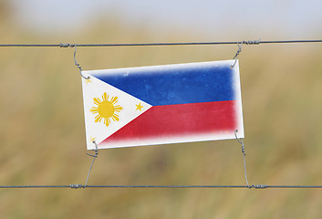 Image showing Border fence - Old plastic sign with a flag