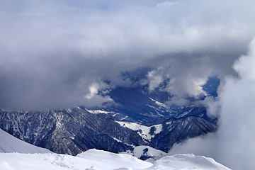 Image showing Top view on winter snowy mountains in clouds