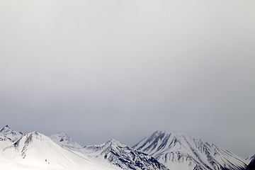 Image showing Gray snowy mountains in mist