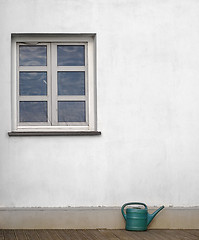 Image showing plastic watering can near the white wall