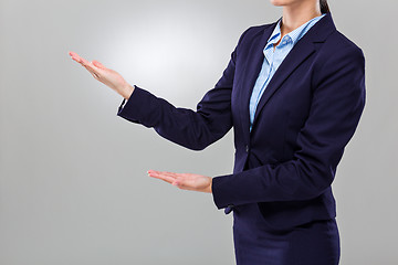 Image showing Businesswoman with two hand presentation