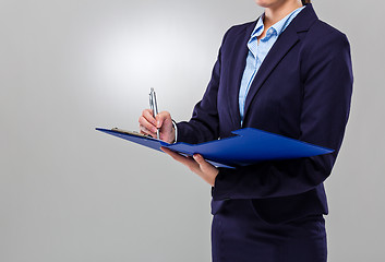 Image showing Businesswoman write on clipboard