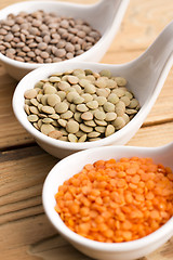 Image showing Three kinds of lentil in bowls - red lentil, green lentil and br