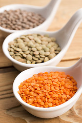 Image showing Three kinds of lentil in bowls - red lentil, green lentil and br