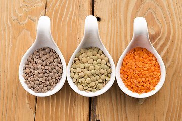 Image showing Three kinds of lentil in bowls - red lentil, green lentil and br