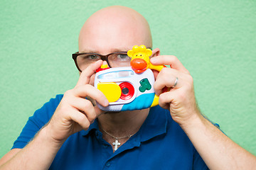 Image showing Young man taking photo with toy camera