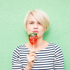 Image showing Young sexy woman sucking lollipop. 