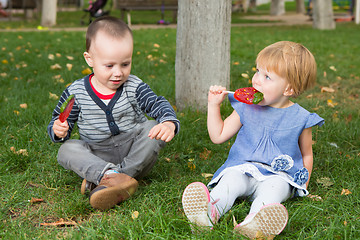 Image showing Adorable little kids with colorful lollipops