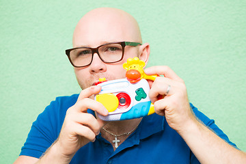 Image showing Young man taking photo with toy camera