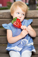 Image showing Beautiful little girl holding strawberry shaped lollipop