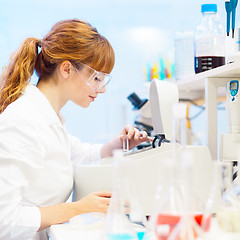 Image showing Attractive young scientist pipetting.