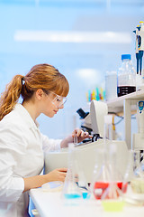 Image showing Attractive young scientist pipetting.