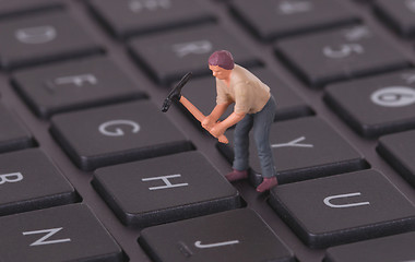 Image showing Miniature worker working on keyboard